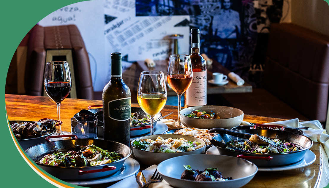 A table with plates of food and wine on it.