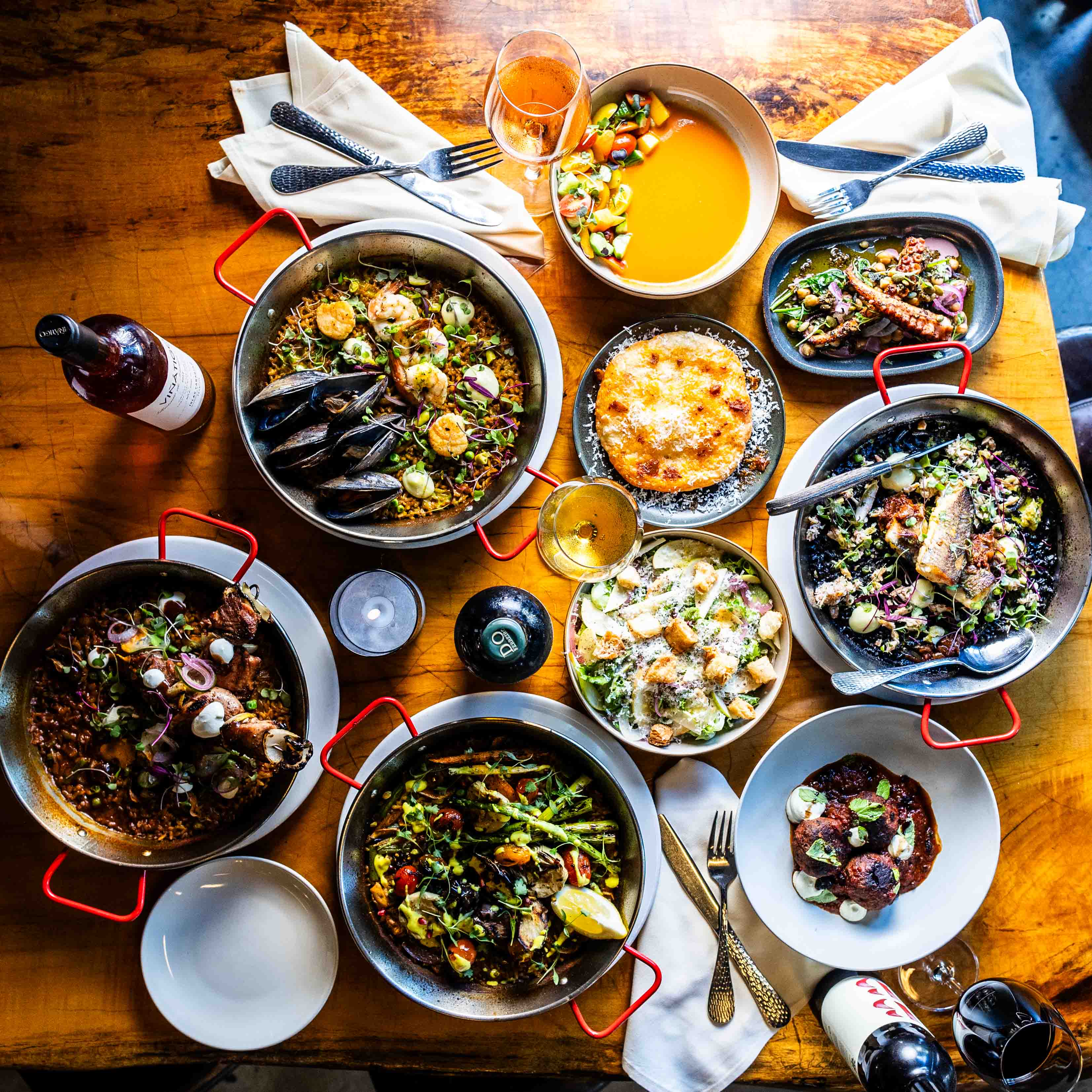 A wooden table topped with lots of bowls and plates.