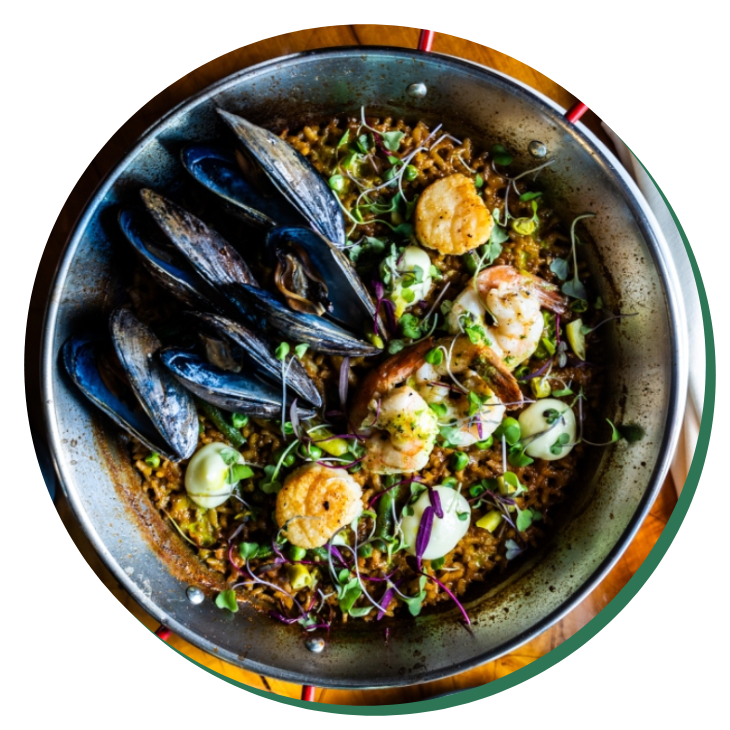 A bowl of food with mussels and shrimp.