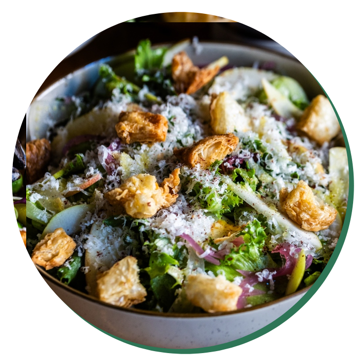 A bowl of salad with broccoli, cheese and croutons.