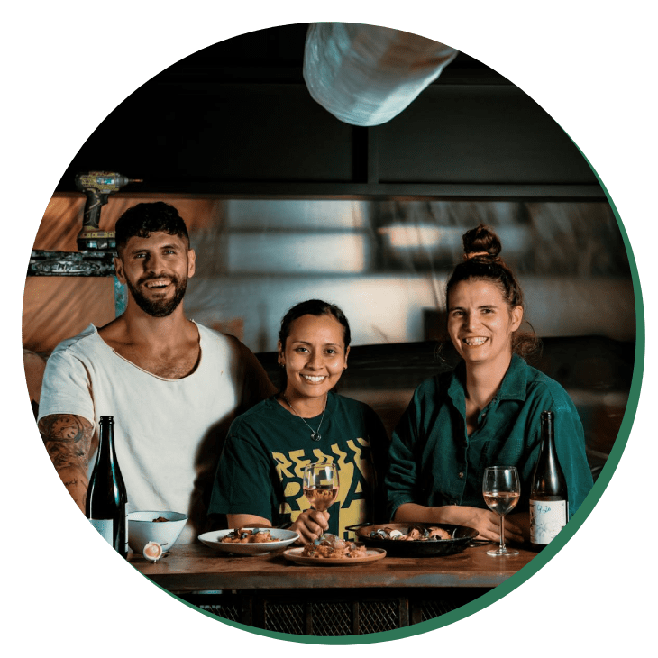 Three people sitting at a table with food.